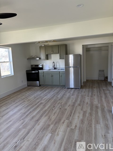 A kitchen with a refrigerator, stove, and sink.