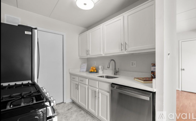 A kitchen with white cabinets and a black stove top.