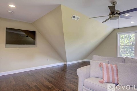 A living room with a couch and a ceiling fan.