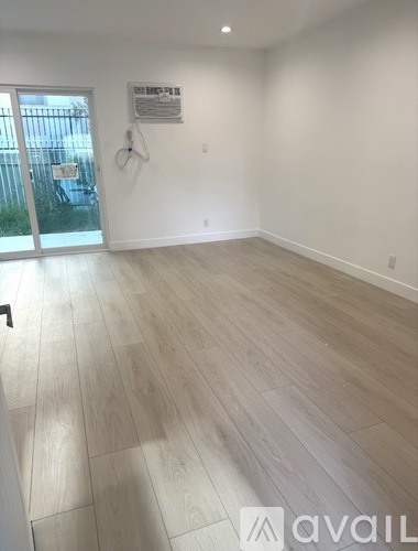 A room with light wooden flooring and white walls.