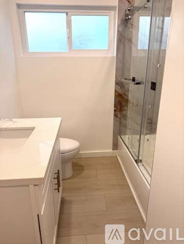 A bathroom with a toilet, sink, and shower.