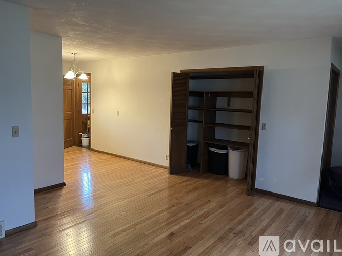 A room with wooden floors and a large wooden bookshelf.