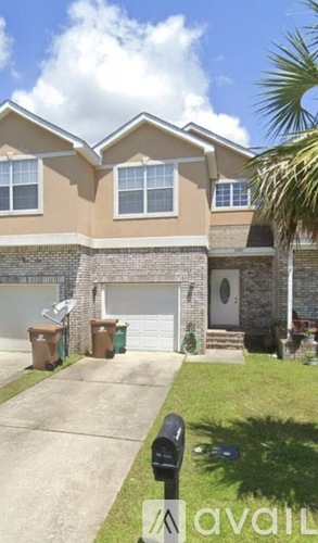 A house with a brown and beige exterior and a white garage door.