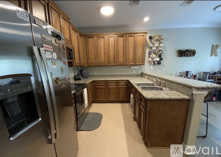 A kitchen with wooden cabinets and a stainless steel refrigerator.