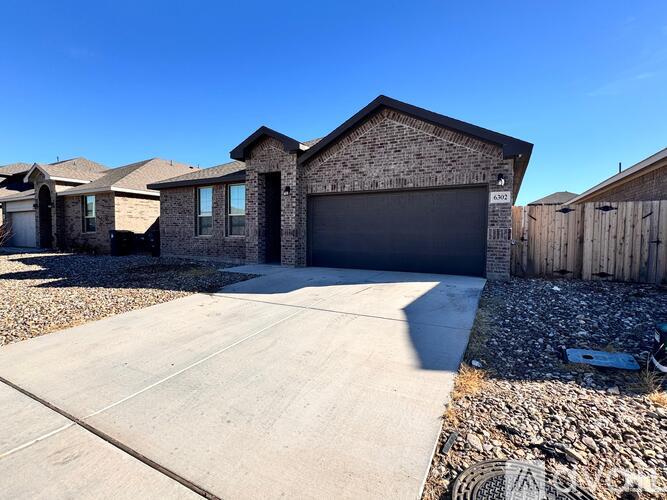 A house with a garage and a driveway in front.