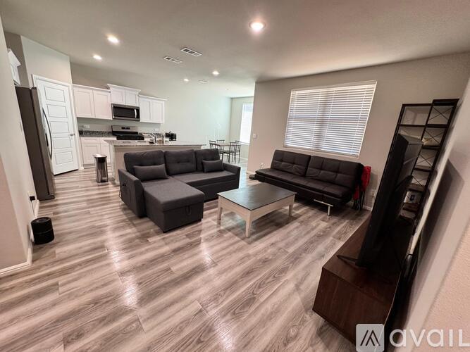 A living room with a grey couch and a black chair.