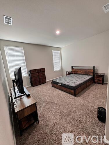 A bedroom with a bed, dresser, and television.