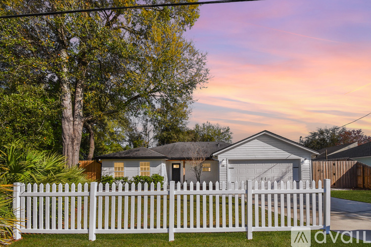 A house with a white picket fence is for sale.
