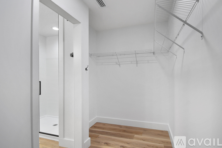 A white room with a wooden floor and a white door.