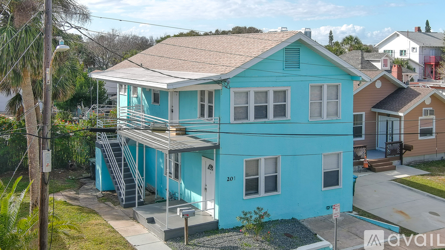 A blue house with a white door and windows.