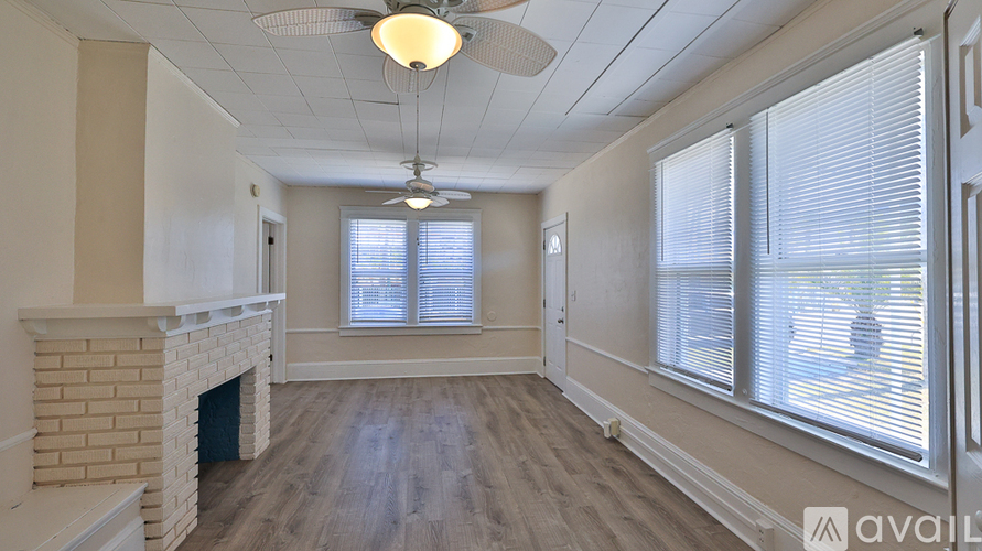 A room with a fireplace and a fan on the ceiling.