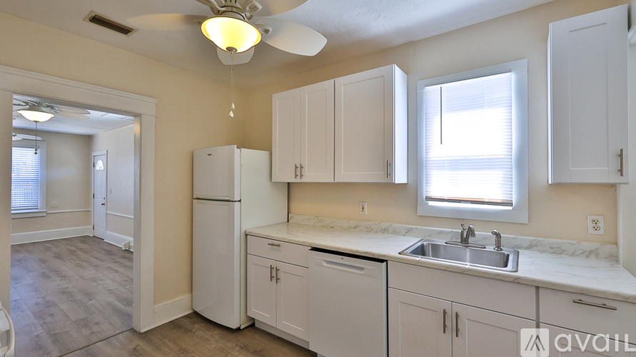 A kitchen with white cabinets and a sink.