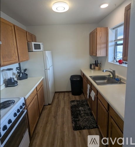 A kitchen with wooden cabinets and a white refrigerator.