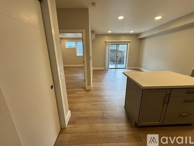 A spacious room with wooden flooring and a white countertop.