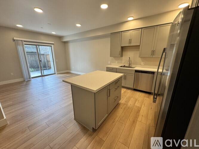 A kitchen with wooden floors and stainless steel appliances.