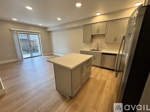 A kitchen with wooden floors and stainless steel appliances.