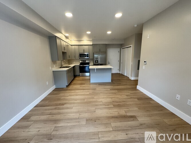 A spacious kitchen with wooden flooring and a countertop.