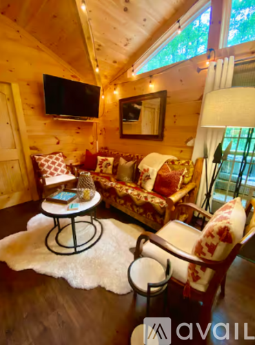 A living room with a couch, chair, and a table with a lamp.
