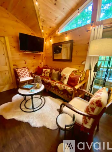 A living room with a couch, chair, and a table with a lamp.