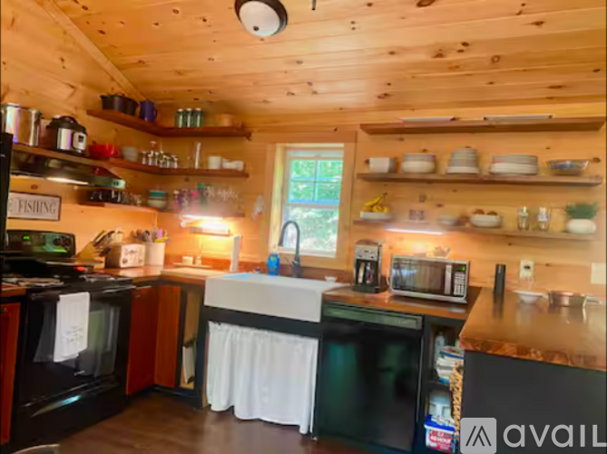 A kitchen with wooden walls and a window.