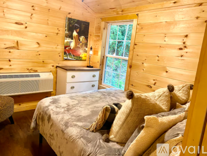 A bedroom with a bed, dresser, and window.