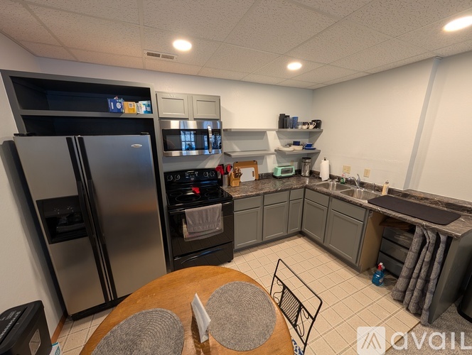 A modern kitchen with a refrigerator, oven, and sink.