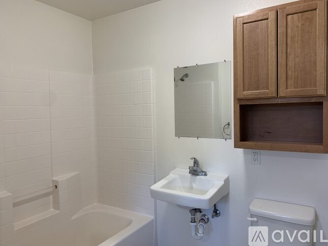 A bathroom with a white tub, sink, and toilet.