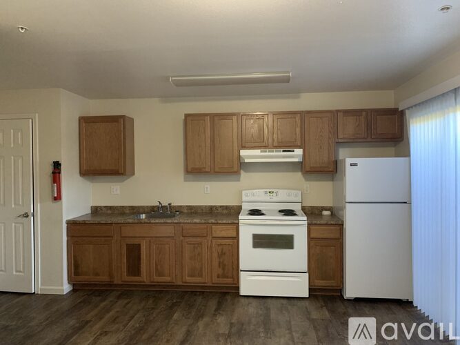 A kitchen with wooden cabinets and a white refrigerator.