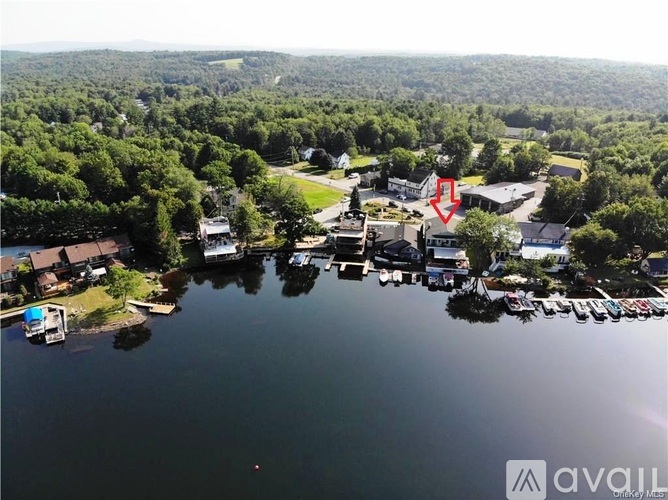 A red arrow points to a building in the middle of a lake surrounded by trees.