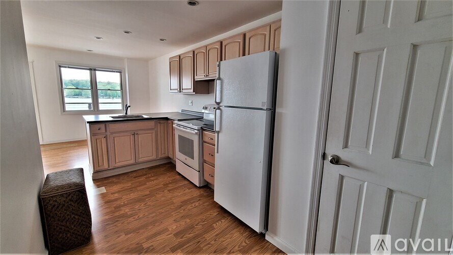 A kitchen with a white refrigerator and wooden floors.