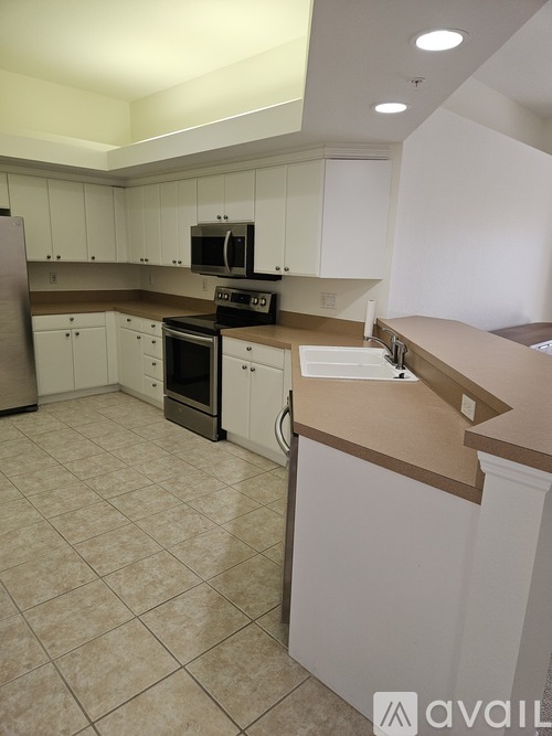 A kitchen with white cabinets and a tiled floor.