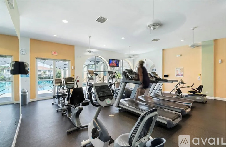 A gym with treadmills and a woman walking on a treadmill.