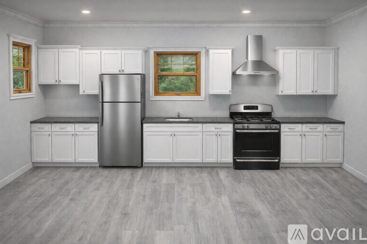 A modern kitchen with a stainless steel refrigerator, oven, and range hood.