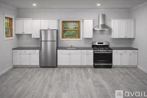 A modern kitchen with a stainless steel refrigerator, oven, and range hood.