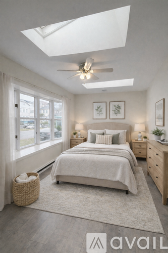 A bedroom with a bed, nightstands, and a window.
