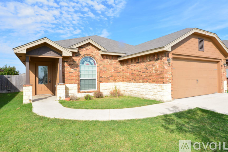 A house with a brown garage door and a brick wall.