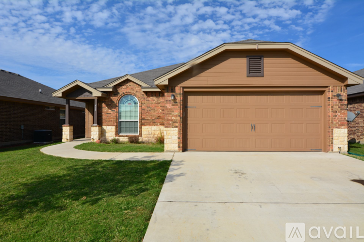 A house with a brown garage door and a brick exterior.