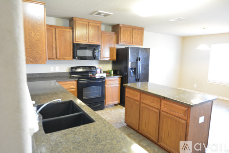 A kitchen with wooden cabinets and black appliances.