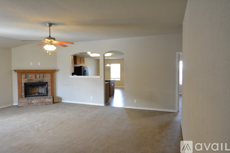 A living room with a fireplace and a ceiling fan.