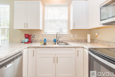 A kitchen with white cabinets and a granite countertop.