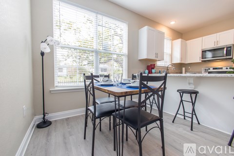 A dining room with a table and chairs.