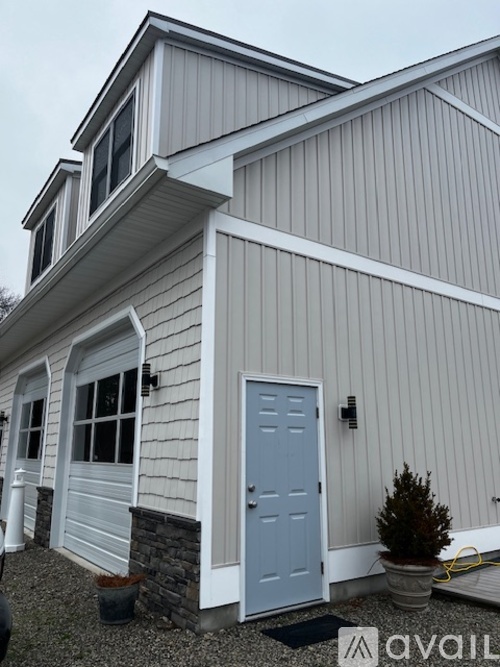 A house with a grey and white exterior and a blue door.