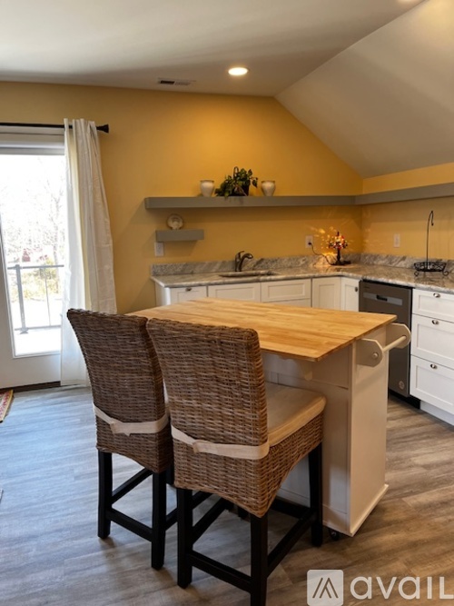 A kitchen with a table and chairs.