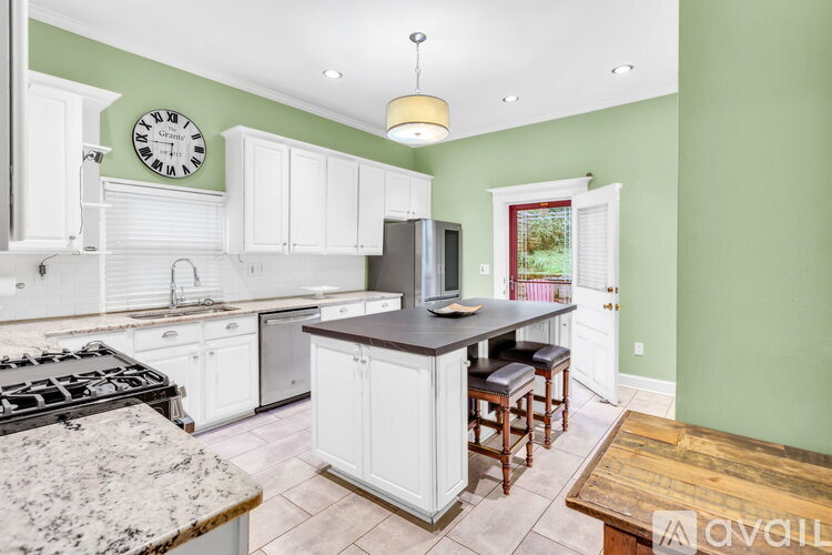 A kitchen with white cabinets and a granite countertop.