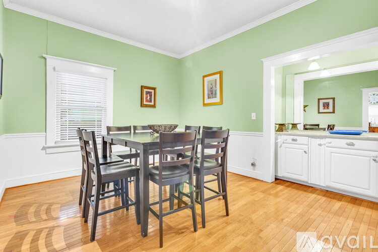 A dining room with a table and chairs.