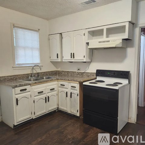 A kitchen with white cabinets and a black stove top oven.
