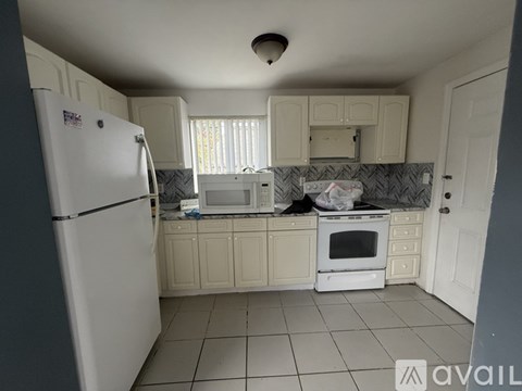 A kitchen with white appliances and cabinets.