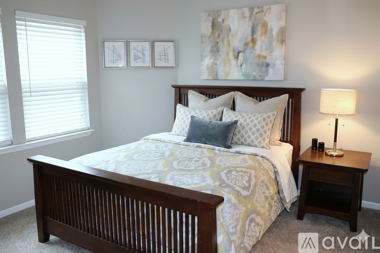 A bedroom with a bed, nightstand, and window.