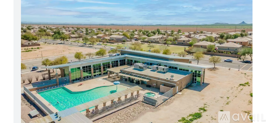 A large building with a pool in the foreground and a mountain in the background.