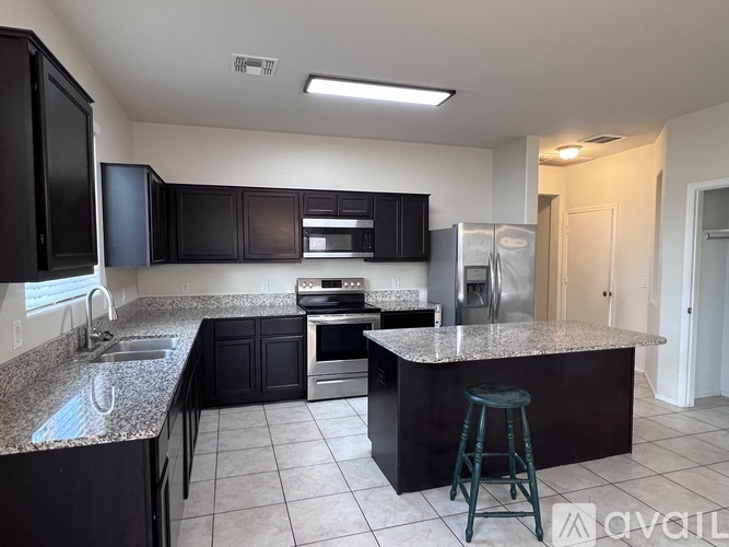 A kitchen with black cabinets and granite countertops.